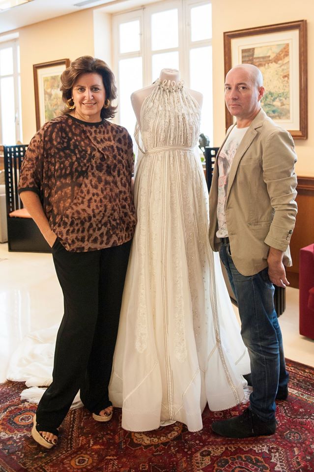 Los diseñadores junto al vestido de novia elaborado con tela de un paracaídas.